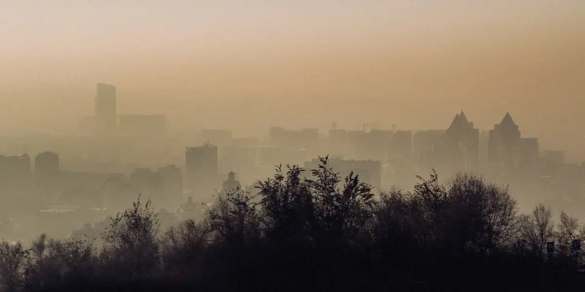 A foggy, smog-filled skyline with buildings barely visible through the haze.