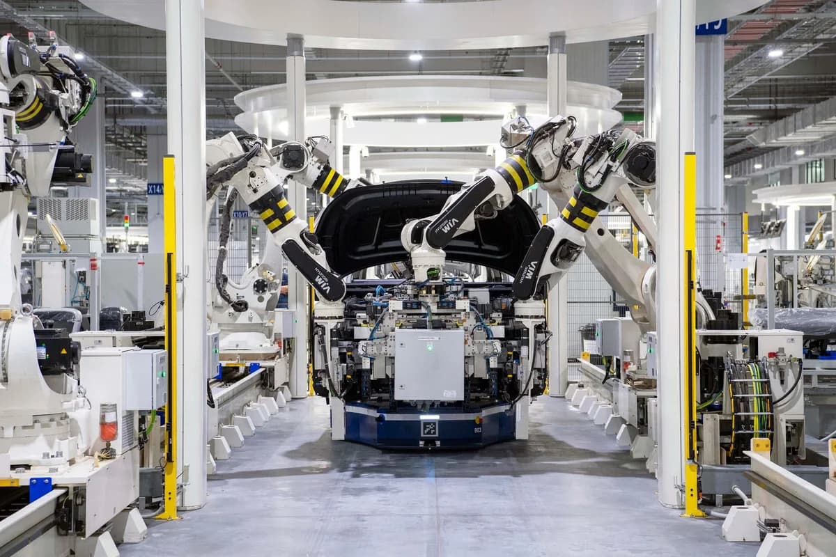 Robotic arms assembling a car in a modern factory.