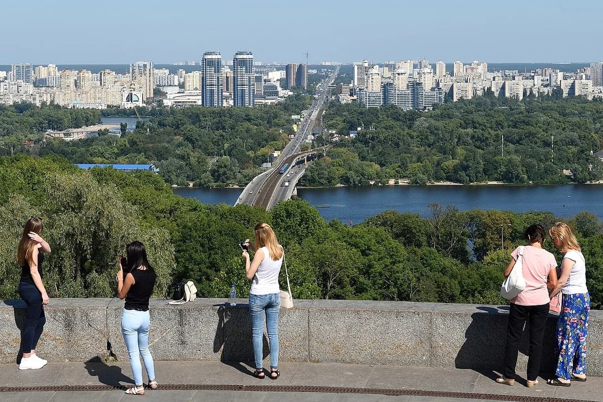 People look out over the Dnipro River and Metro Bridge in Kyiv.