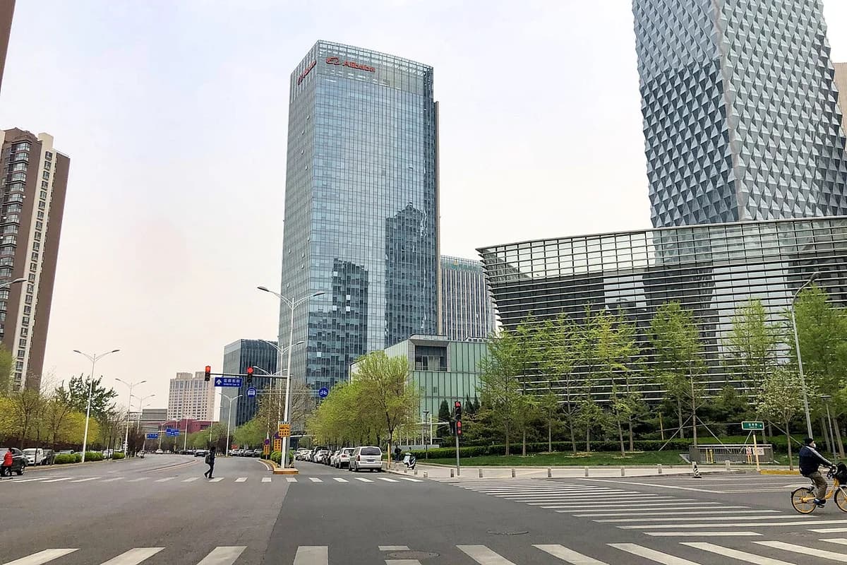 Alibaba headquarters tower in Wangjing, Beijing, beside a modern city street.