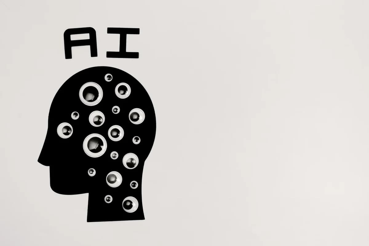 Abstract image of a black head silhouette filled with many eyes, with "AI" above it.