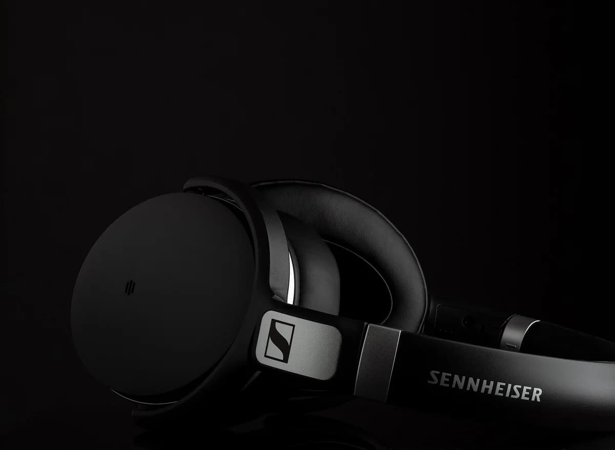 Close-up of black Sennheiser over-ear headphones on a dark background.