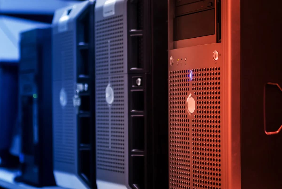 Close-up of tower servers in a data center with blue lighting on the left and red lighting on the right.
