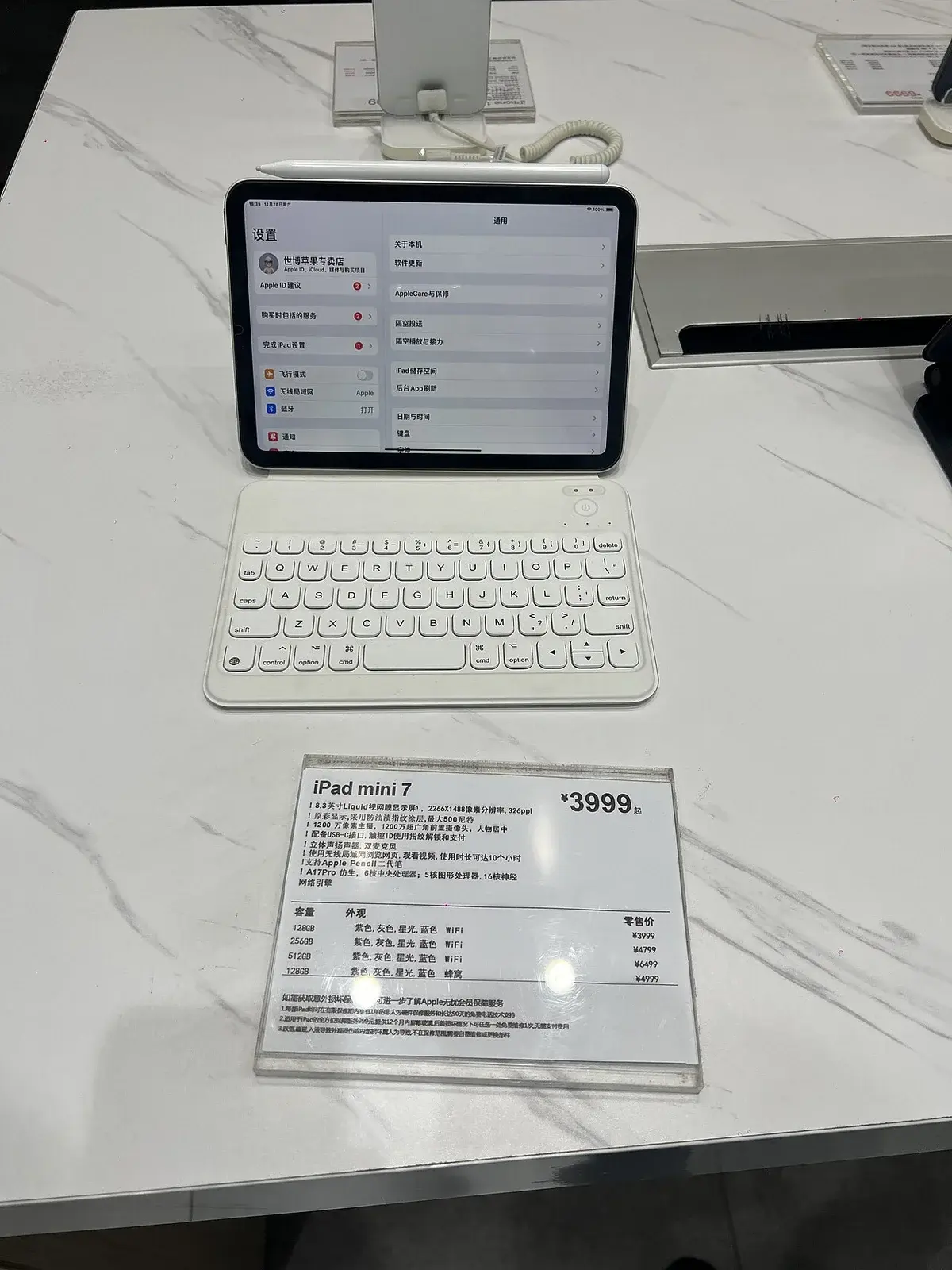 An iPad mini 7 on display with a keyboard and price sign.