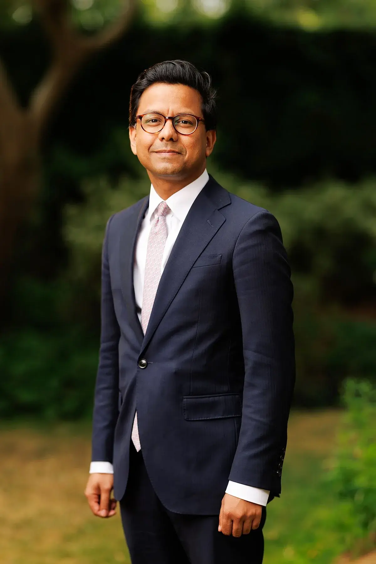 Portrait of Kanishka Narayan in a suit outdoors.