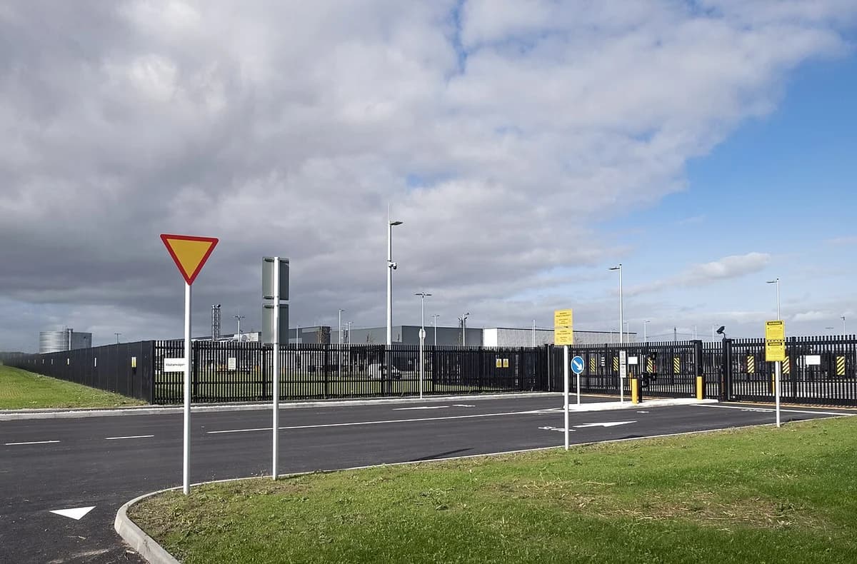 A fenced Microsoft data center site under construction beside a road.