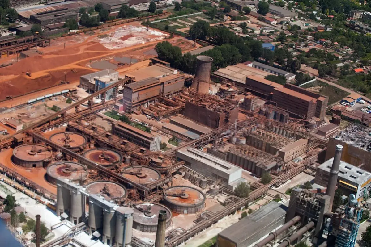 Aerial view of a large industrial factory complex near a town.
